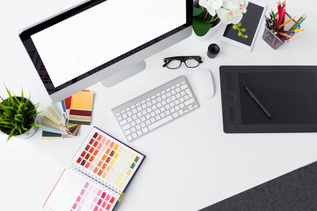 A white table featuring various tools that assist with graphic design.